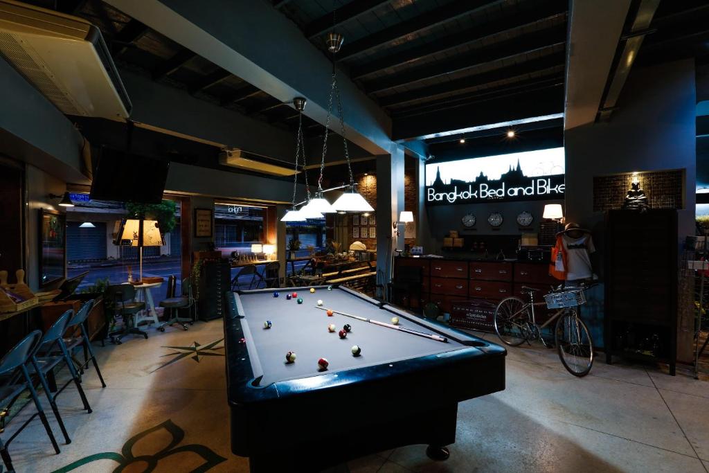 a pool table in the middle of a room at Bangkok Bed and Bike in Bangkok