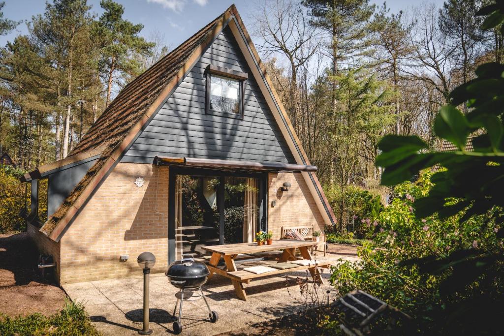 a tiny house with a picnic table and a grill at Boshuisje Rekem - Topo in Lanaken