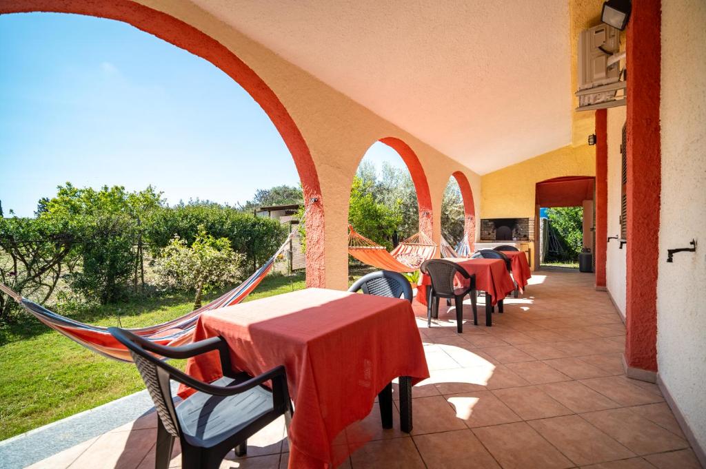 a patio with tables and chairs in a restaurant at Resonance Experience - Peaceful Stay near Cagliari, Beaches & Nature in Sant' Isidoro