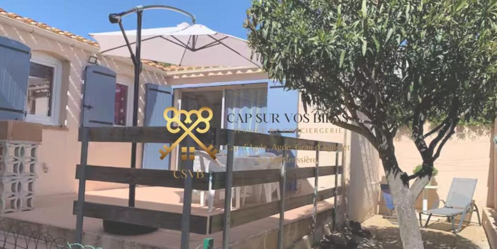 une maison munie d'un panneau avec un ruban jaune dans l'établissement Charmante maison avec sa terrasse au soleil, au Cap d'Agde