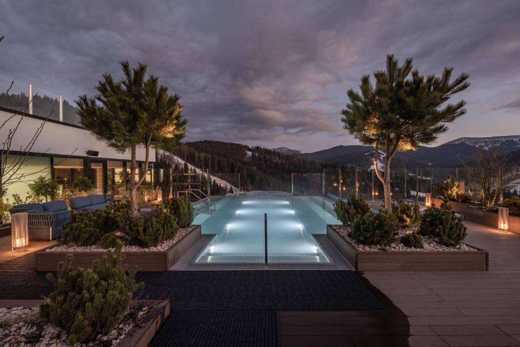 a swimming pool at night with trees and a building at Mountain Residence Wellness & SPA in Bukovel