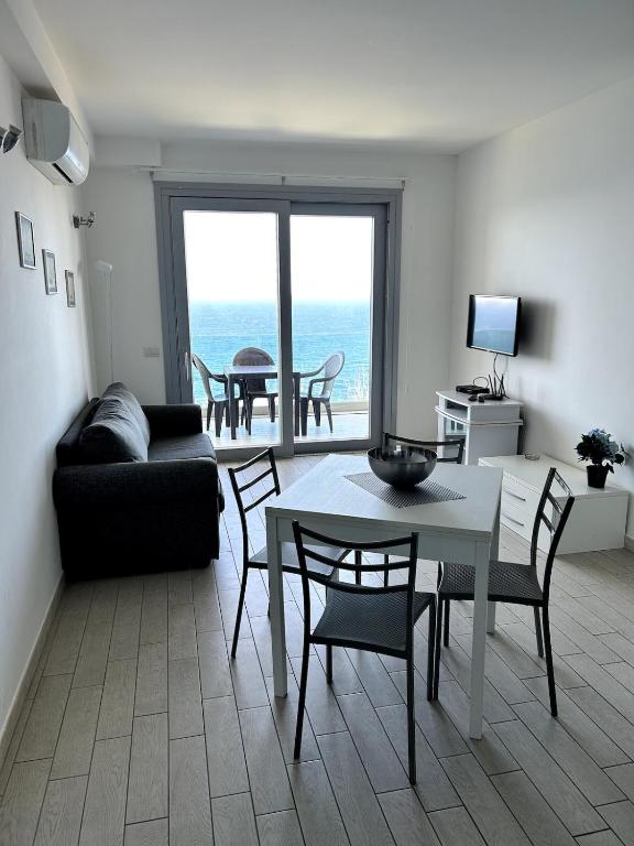 a living room with a table and chairs and a couch at Feli's Apartment in Castelsardo