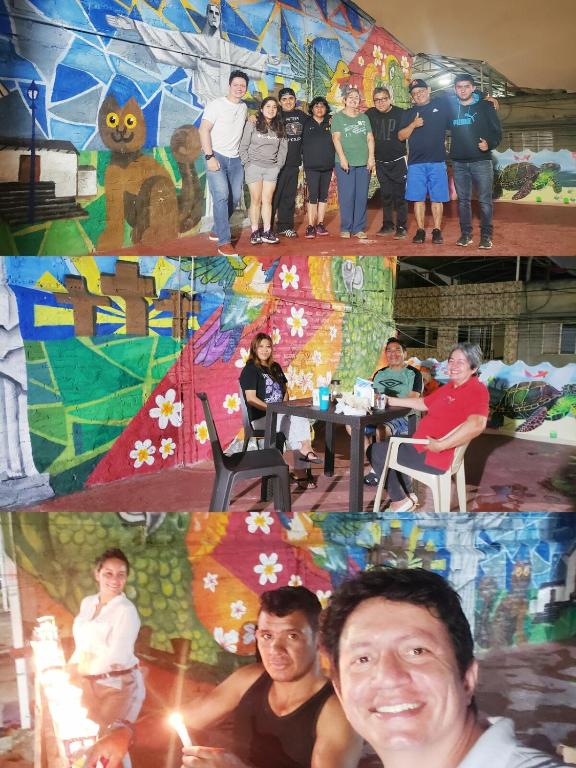 a group of people standing and sitting in front of a painting at Mom's House Colombia Casa 2 in Cali