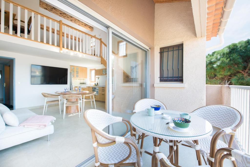 un salon avec une table et des chaises dans l'établissement 2 Chambres, proche des plages, parking, à Fréjus