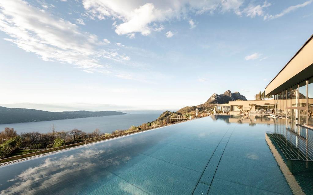 a swimming pool with a view of the water at Stroblhof Lake Garda Active Family SPA Resort in Gargnano