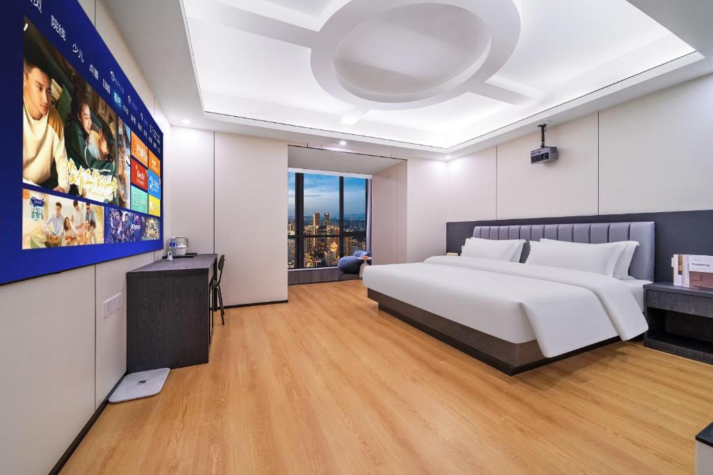 a bedroom with a large white bed and a tv at Sky Congbo High-altitude River View Hotel in Chongqing