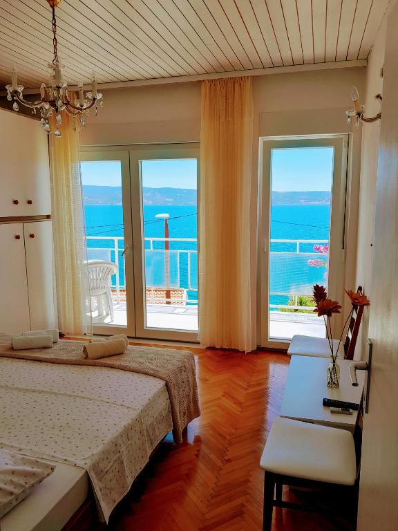 a bedroom with a bed and views of the ocean at EmTo Suhi Potok in Jesenice