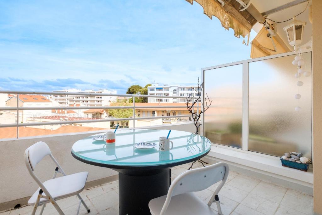 une table et des chaises sur un balcon avec vue dans l'établissement Appartement Jardin de Monfleury, à Cannes