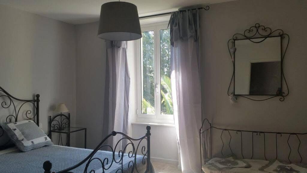 une chambre avec un lit et une fenêtre dans l'établissement La Bastide de Marie, à Saint-André-de-Roquelongue