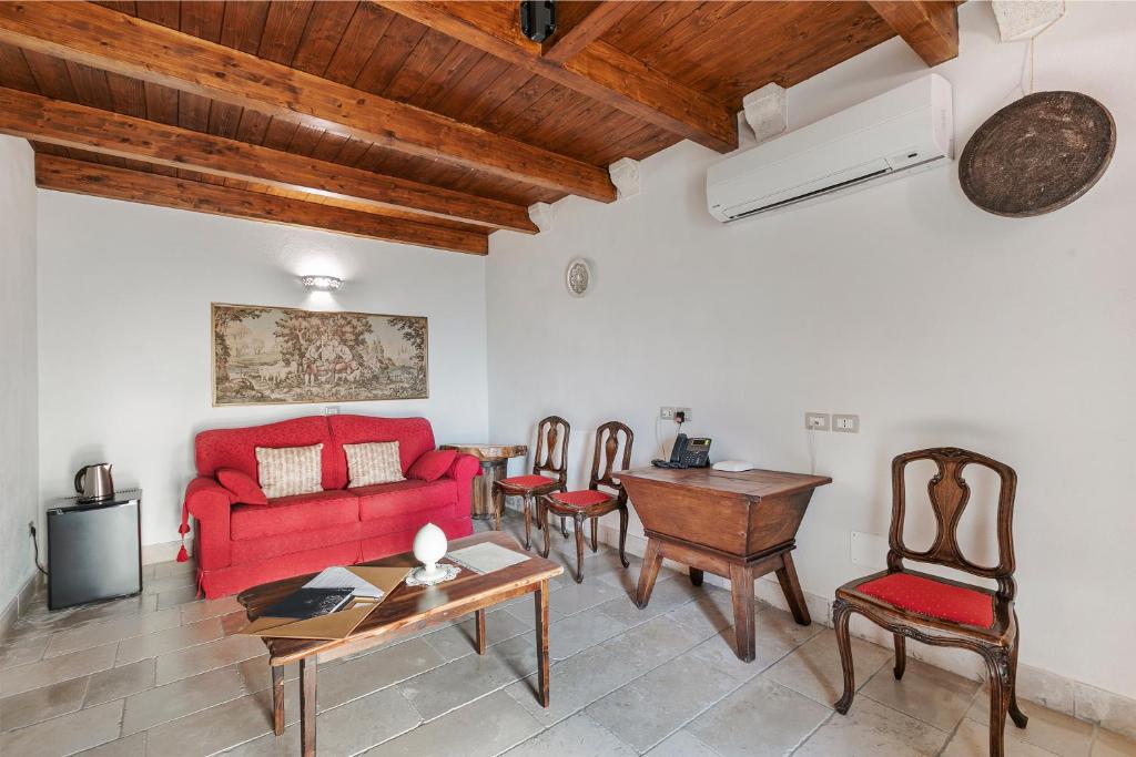 salon z czerwoną kanapą i krzesłami w obiekcie Masseria Antoglia Rooms w mieście Villa Castelli