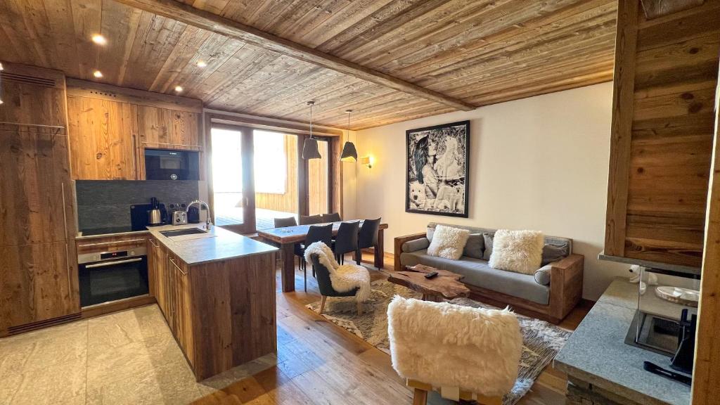 une cuisine et un salon avec un canapé et une table dans l'établissement Résidence KILIMANDJARO - appt 3 pièces 60m2 - by Hotel MontBlanc, à Val dʼIsère