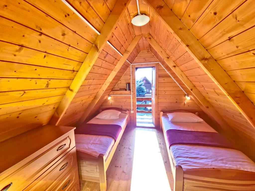 Postel nebo postele na pokoji v ubytování Domki Słoneczko z dostępem do jacuzzi sauny i rowerów w cenie