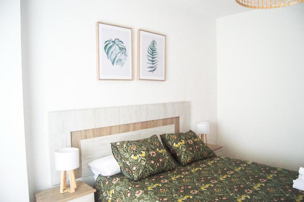 a bedroom with a bed and two pictures on the wall at MoMA Meanas Aviles Centro in Avilés