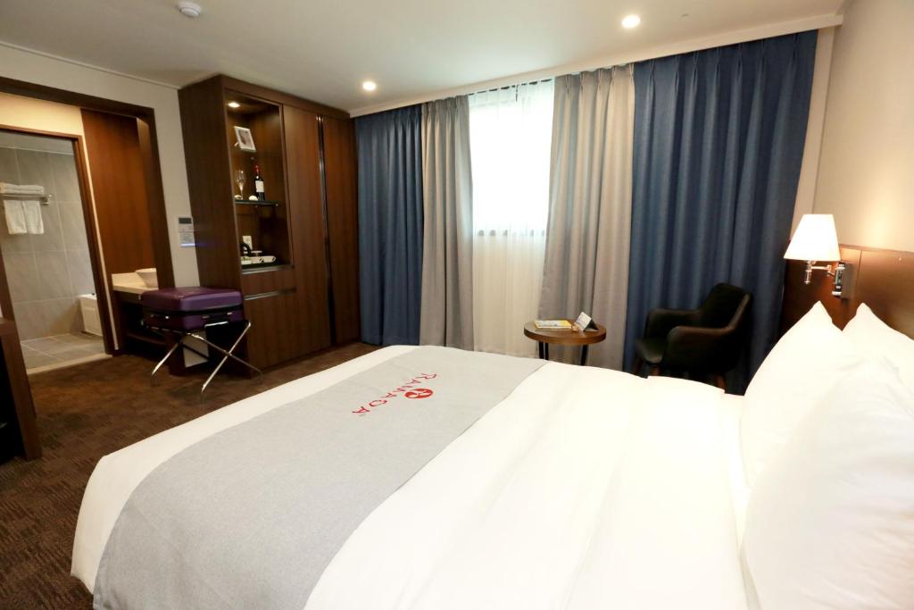 Postel nebo postele na pokoji v ubytování Ramada Taebaek Hotel