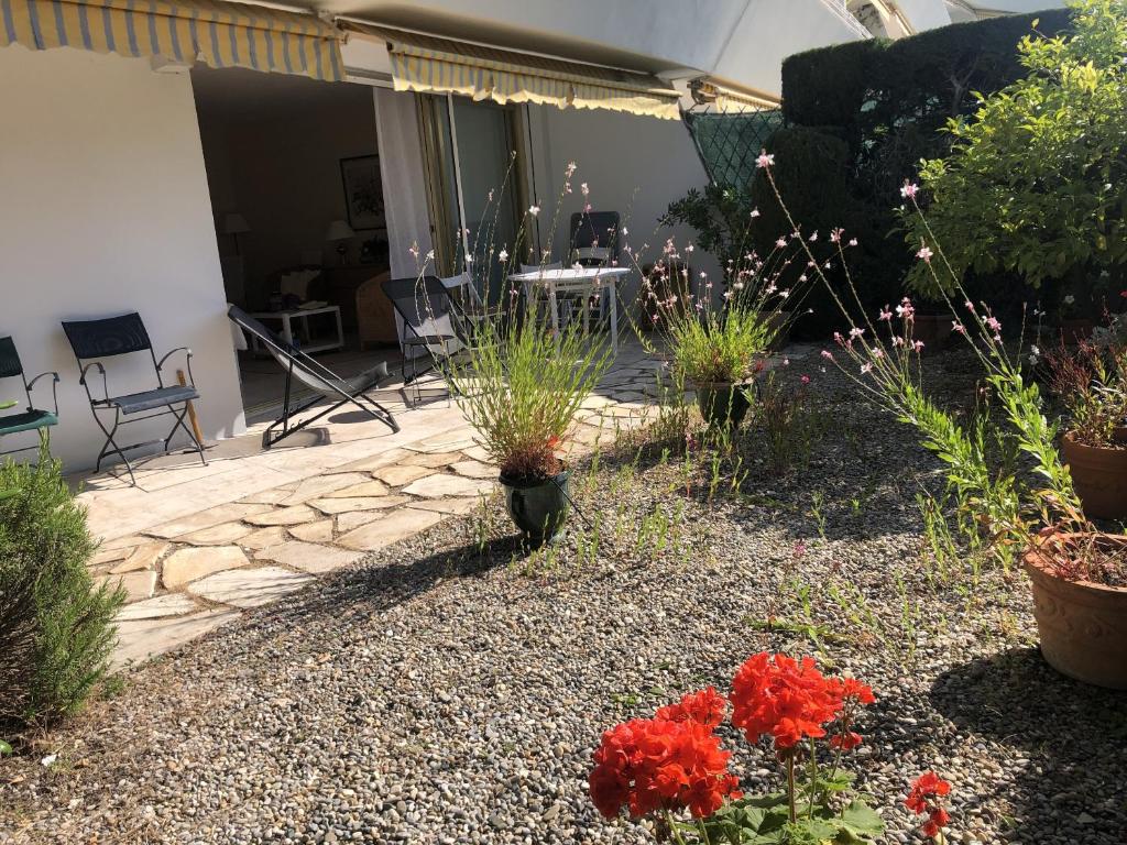 un jardin avec des fleurs et des plantes dans une cour dans l'établissement Les Oliviers 3, Domaine de Pierre Longue, à Cannes