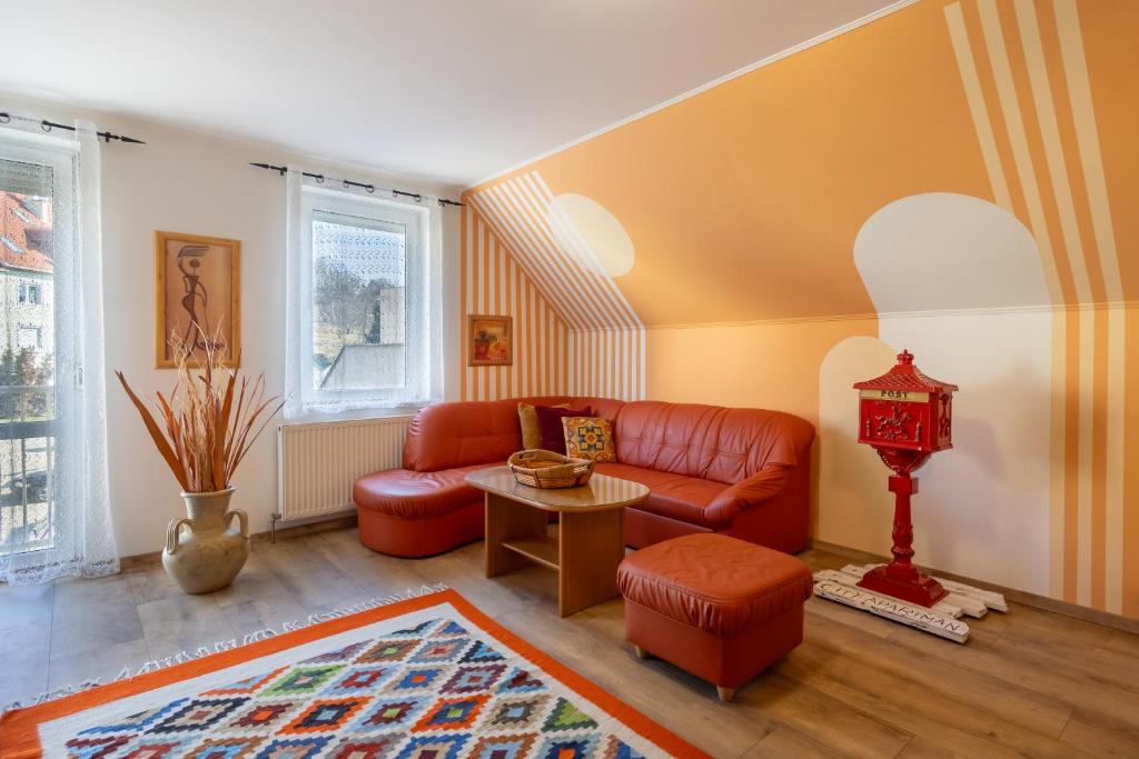 a living room with a red couch and a table at City Apartman Eger in Eger