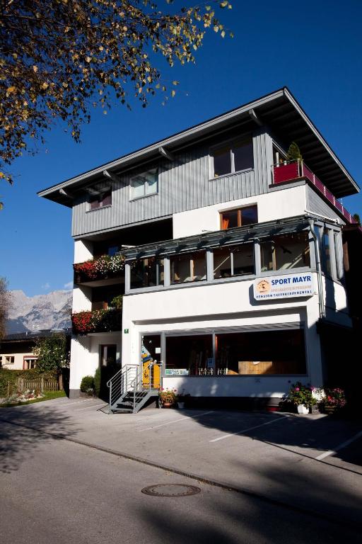 a white building with a sign on the front of it at Frühstückspension Sport Mayr in Söll