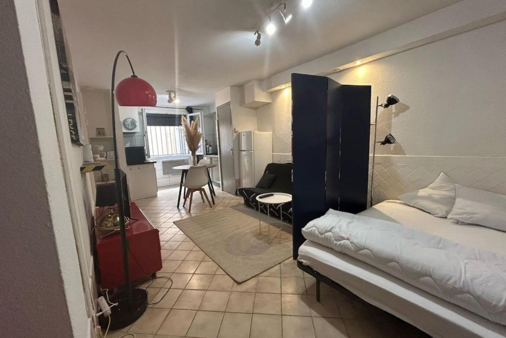 une chambre avec un lit et un salon dans l'établissement Le Moulin - Grand studio - Gare, à Narbonne