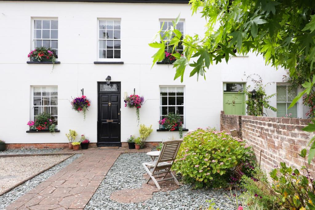 a white house with a green door and a chair at Berwick House in Sidmouth
