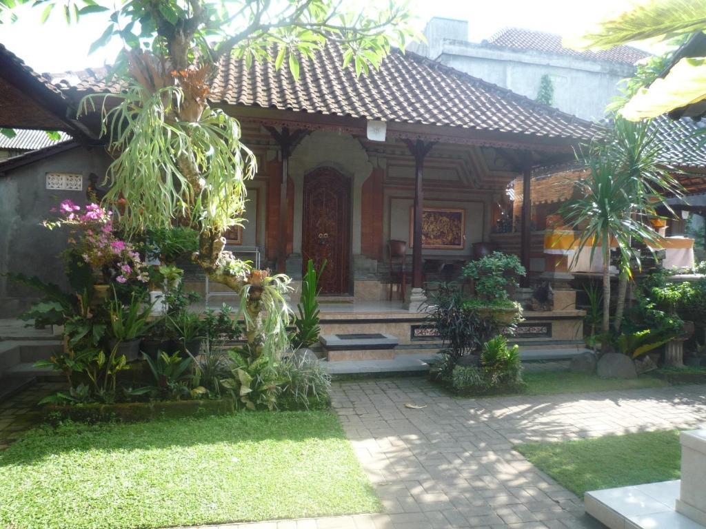 Une petite maison avec beaucoup de plantes devant elle dans l'établissement Shindu Home Stay, à Ubud