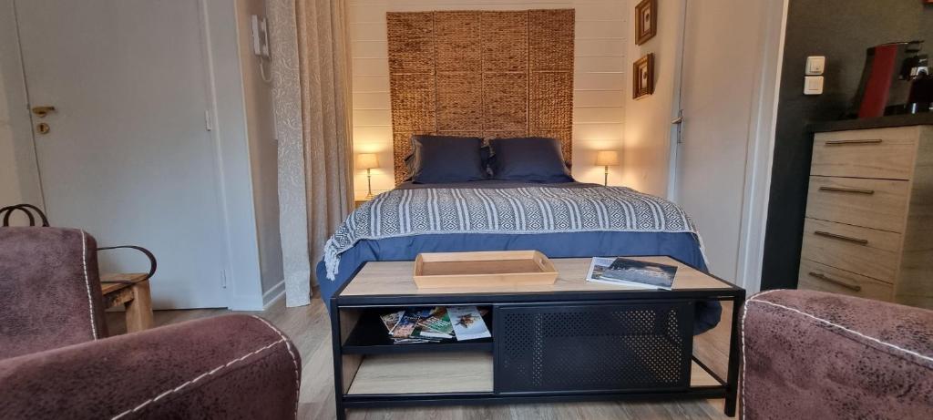 a bedroom with a bed with a table and two chairs at Le TOURNY-Studio cosy avec ascenseur- Sarlat - Coeur cité médiévale in Sarlat-la-Canéda