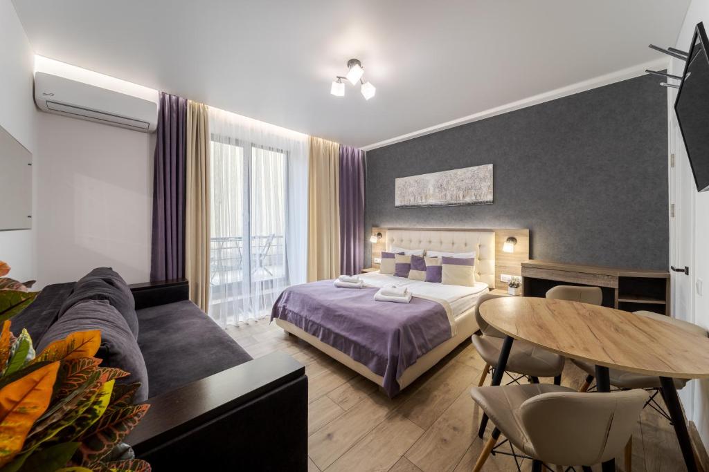 a bedroom with a bed and a table and a couch at DeMar Apart Violet in Lviv