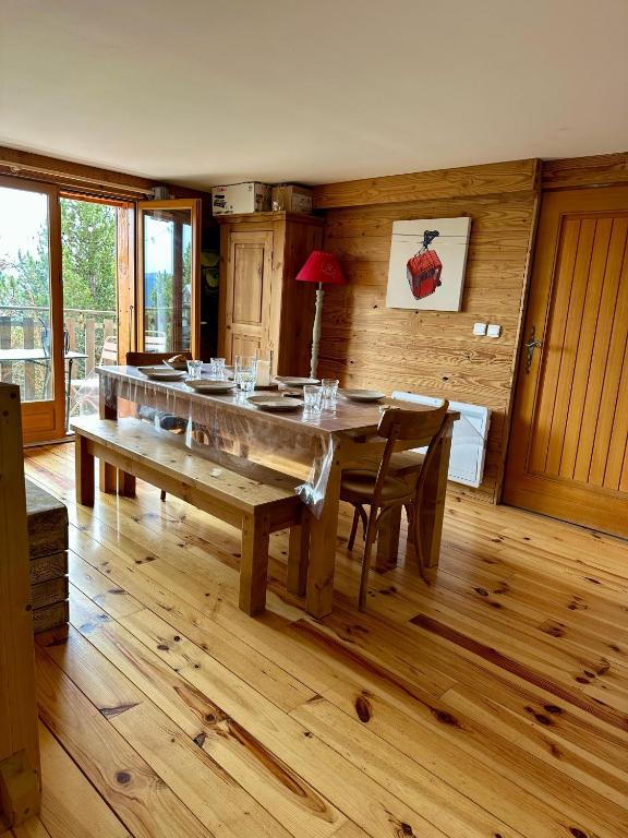 une salle à manger avec une grande table et des chaises en bois dans l'établissement Appartement cocooning aux Angles, aux Angles