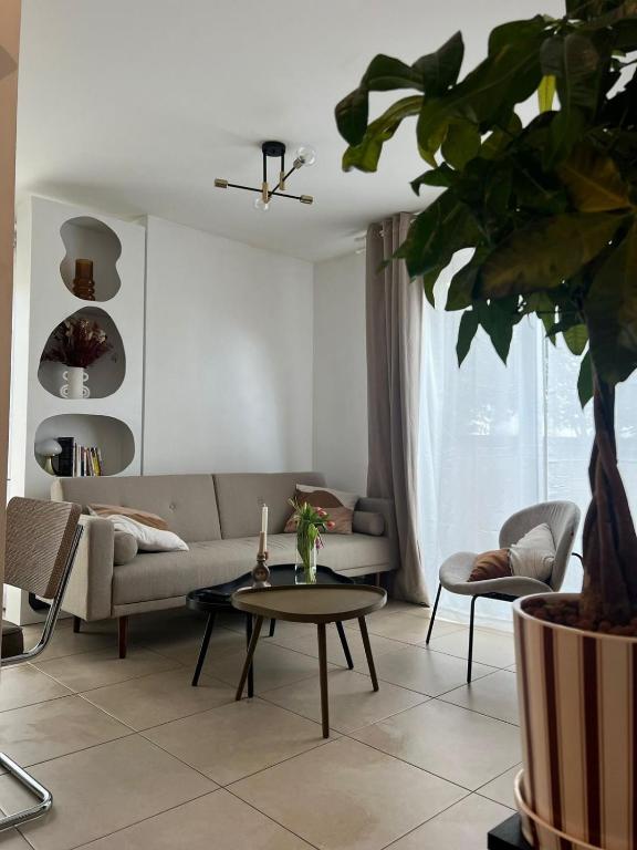 un salon avec un canapé et une table dans l'établissement Charmant logement - CDG & Astérix, à Vémars