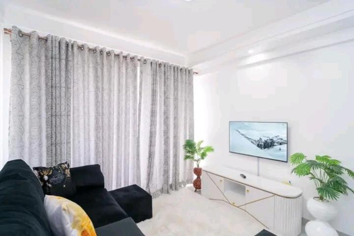 een woonkamer met een bank en een groot raam bij NOVAH Apartments NAIROBI KENYA in Nairobi