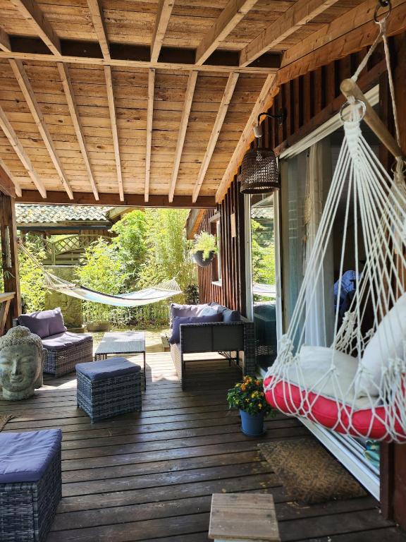 - une terrasse couverte avec un hamac dans une maison dans l'établissement Chalet tout confort et tout équipé, à La Teste-de-Buch