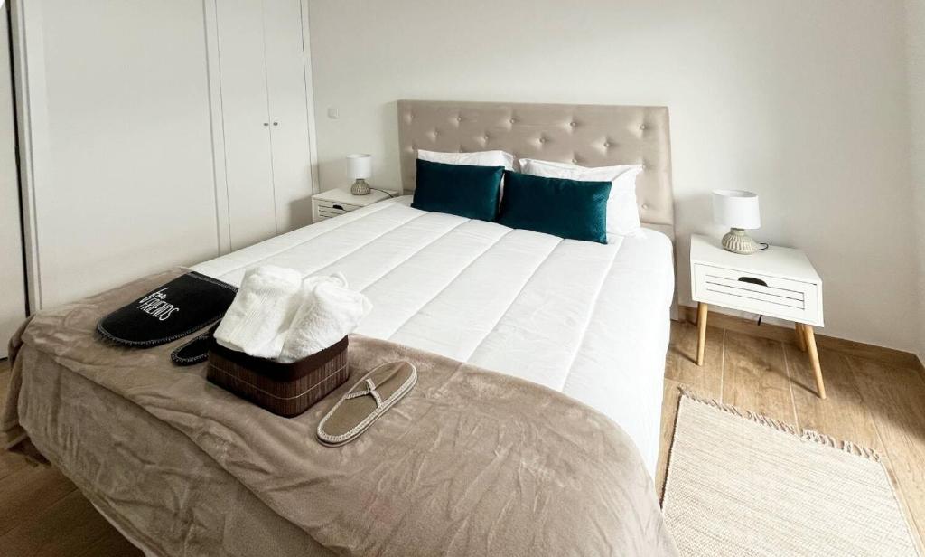 um quarto com uma grande cama branca com travesseiros azuis em R3 - Casinha PP GH em Coimbra