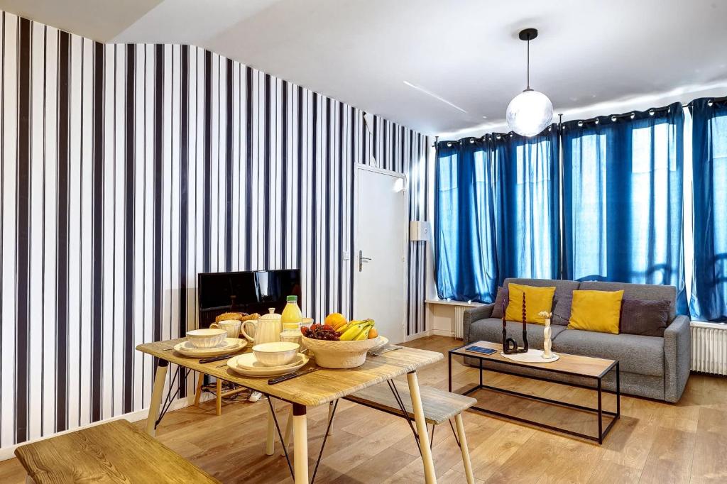 un salon avec une table et un canapé dans l'établissement Charme contemporain pres de La Villette - 4P, à Paris