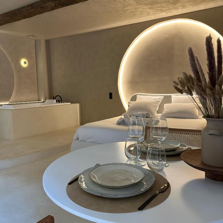 Cette chambre comprend une table avec des verres et un lit. dans l'établissement Maison Paume - Collection AURA - Charleville-Mézières à deux pas de la Place Ducale, à Charleville-Mézières