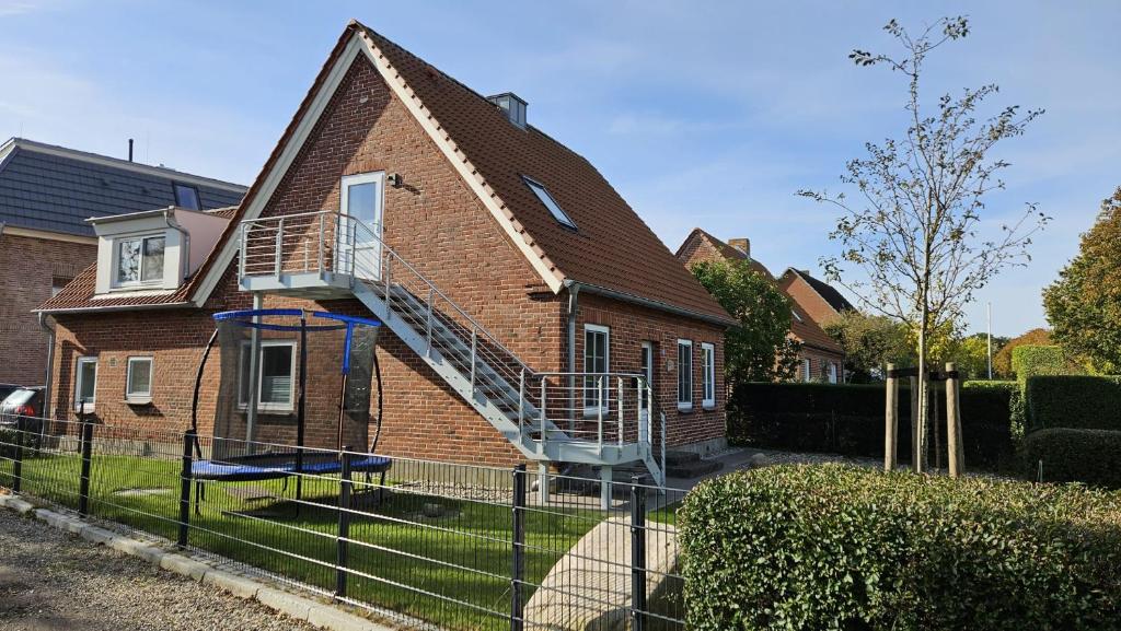 a brick house with a staircase on the side of it at FeWo Gisela in Fehmarn