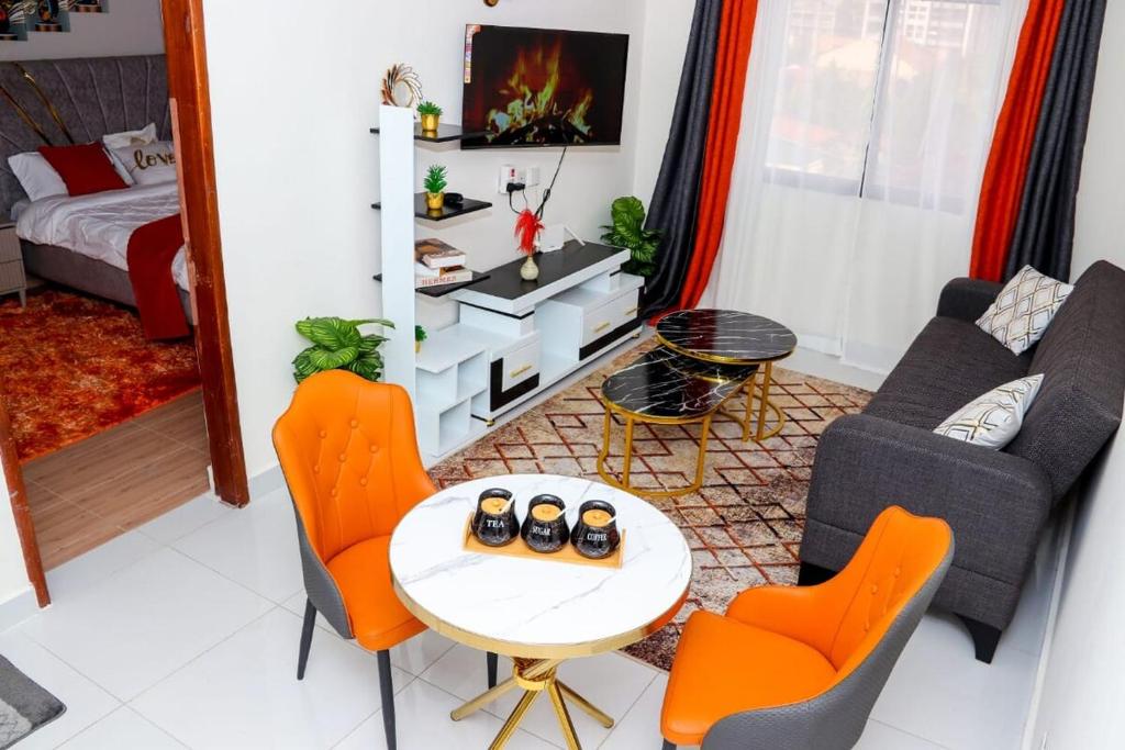 a living room with orange chairs and a table at 1 Bedroom Apartment in Syokimau near Airport and SGR in Nairobi