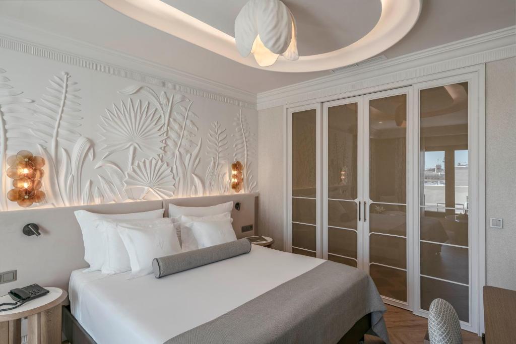 a bedroom with a white bed and a chandelier at Vincci Centrum in Madrid