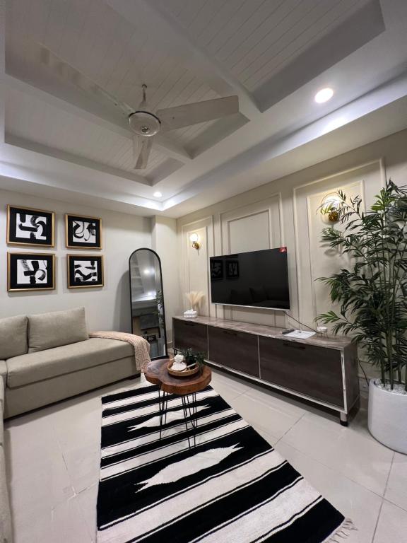 a living room with a couch and a tv at Casa Bianca- Flat in Islamabad in Islamabad