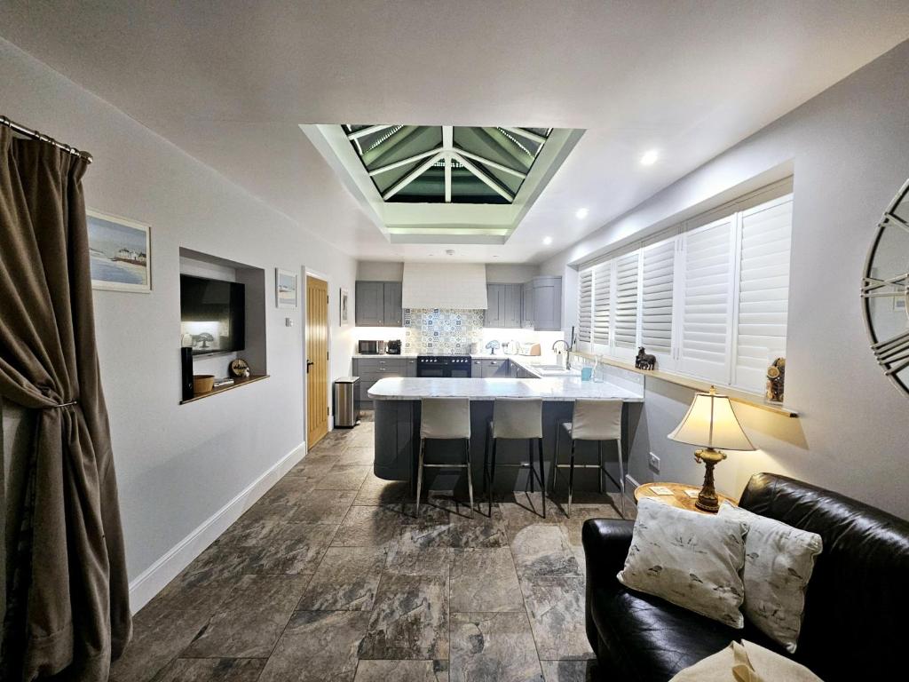 a kitchen and living room with a couch and a table at Holly Cottage in Hutton le Hole