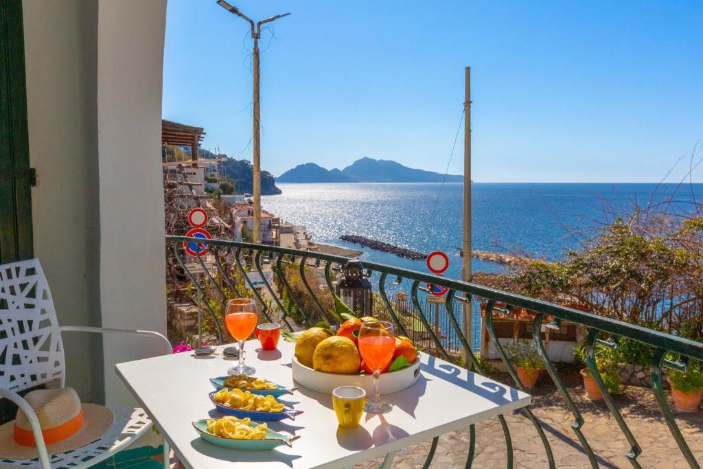 a table with food and drinks and a view of the ocean at Estate4home - Suite Bonview in Massa Lubrense