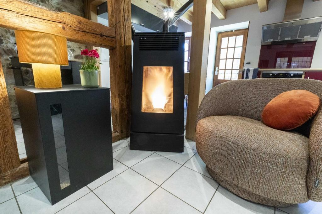 a living room with a fireplace and a chair at Ide'Alsace in Eguisheim