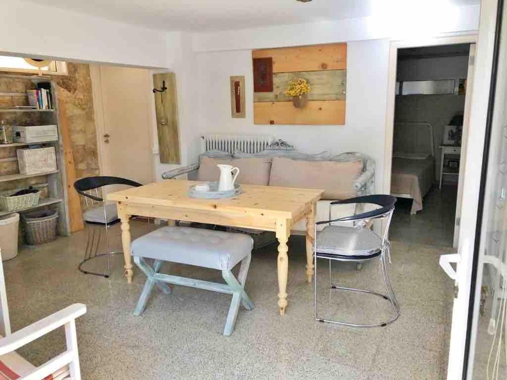 a wooden table and chairs in a living room at Heraklion-Pinelopi Apartment in Ayía Marína