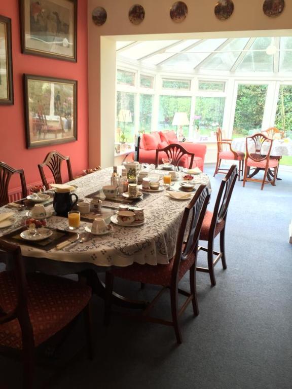 a dining room with a table with dishes on it at Kingswood Cottage in Lyndhurst