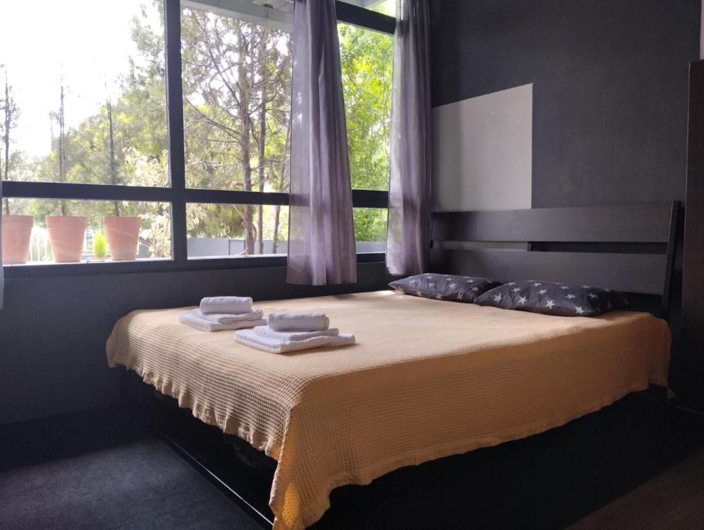 a bed in a room with a window with towels on it at Mona Lisa Guest House in Volos