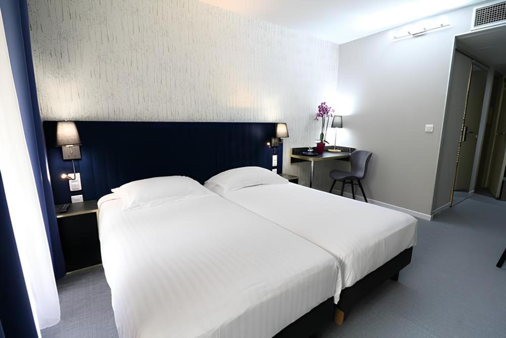 Postel nebo postele na pokoji v ubytování Hôtel Napoléon