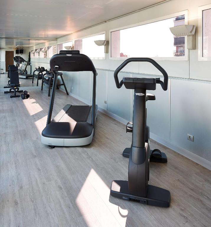a gym with exercise bikes and a treadmill at NH Barcelona Stadium in Barcelona