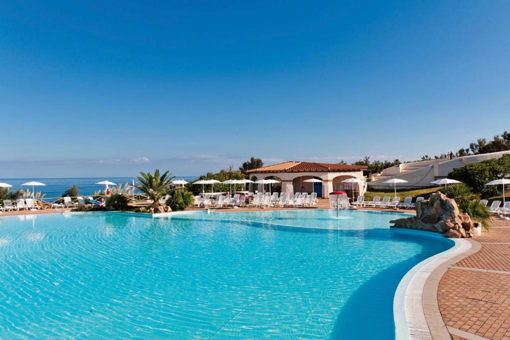 ein Swimmingpool in einem Resort mit blauem Wasser in der Unterkunft Futura Style Acqua di Mare Resort in Marina di Sorso