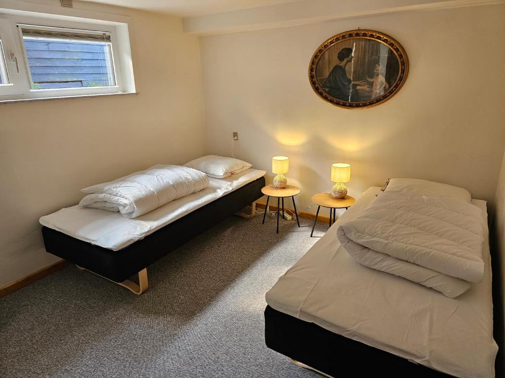 two beds in a bedroom with two lamps and a mirror at Dream Sleep Inn in Aalborg