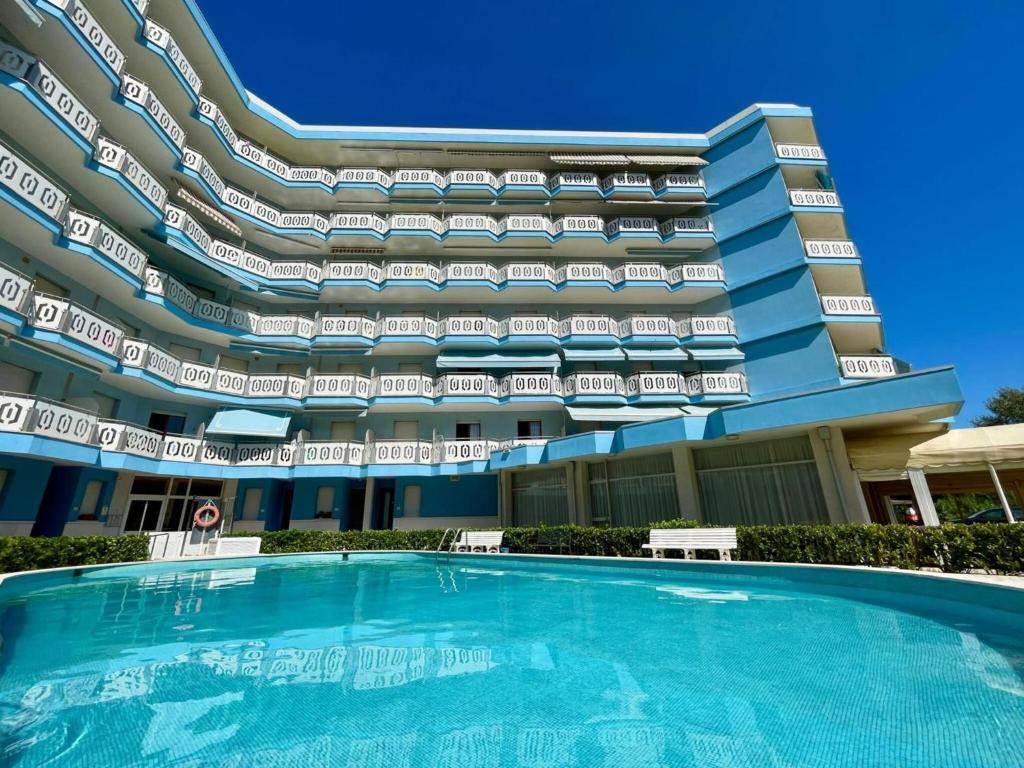 hotel z basenem przed budynkiem w obiekcie Fresh and cozy seaside studio w mieście Porto Santa Margherita di Caorle