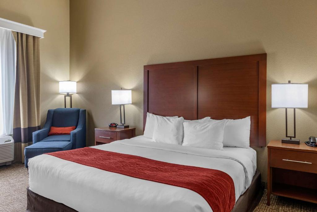 een hotelkamer met een groot bed en een blauwe stoel bij Comfort Inn & Suites Augusta in Augusta