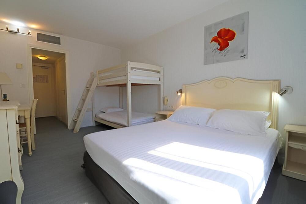 Postel nebo postele na pokoji v ubytování Hôtel Napoléon